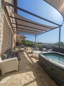a patio with a hot tub and chairs and a table at Rosemar in Peyriac-de-Mer