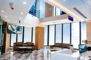 a lobby with couches and tables and large windows at Transit Hotel in Juba
