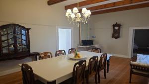 a dining room with a table and chairs and a clock at Paul René Manor House in Robertson