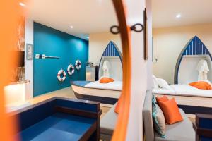 a room with two beds and a blue wall at The Iconic Hotel Ranong in Ranong