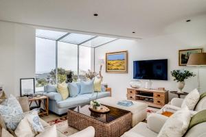 a living room filled with furniture and a large window at Silvertree in Cape Town