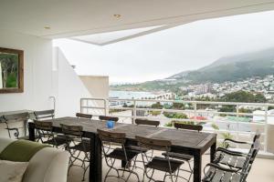 a dining room with a wooden table and chairs at Silvertree in Cape Town +42 photos