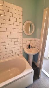 a bathroom with a tub and a sink at Lavish Lounge in Swansea