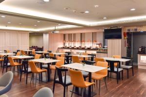 a restaurant with tables and chairs and a kitchen at Holiday Inn Express Taipei Train Station by IHG in Taipei