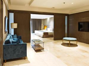 a living room with a bed and a couch and a table at City Garden Suites Manila in Manila