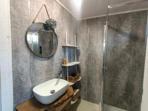 a bathroom with a sink and a mirror and a shower at A Casiña do Río in Celanova +13 photos