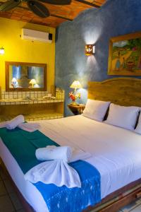 a bedroom with a large bed with towels on it at Cabañas del Capitan in Rincon de Guayabitos +146 photos