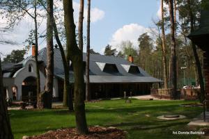 a large building with a gambrel roof on a green yard at Nostalgia in Sokolniki