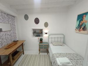 a small bedroom with a bed and a desk at A Casiña do Río in Celanova