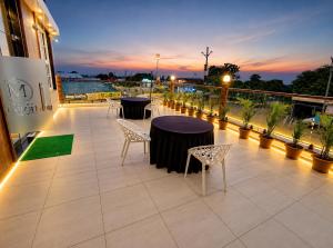 ein Balkon mit Tischen und Stühlen an einem Gebäude in der Unterkunft Hotel Mewada in Ujjain