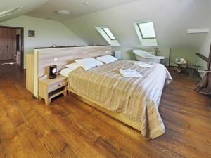 a large bedroom with a large bed and a tub at Hotel Vinohrad in Milotice