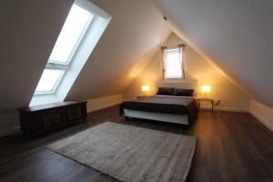 a attic bedroom with a bed and two windows at Kiek-Ut-OG-mit-Studio-Nr-3 in Haby