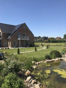 a house with a pond in front of it at Kiek-Ut-OG-mit-Studio-Nr-3 in Haby