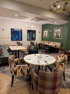 a restaurant with tables and couches and chairs at Craigmonie Hotel Inverness by Compass Hospitality in Inverness