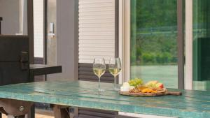 two glasses of wine and a plate of food on a table at Hongcheon Pension 150 in Hongcheon +2 photos