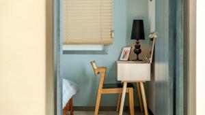 a room with a chair and a table with a lamp at Hongcheon Pension 150 in Hongcheon