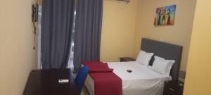 a bedroom with a bed with a red blanket on it at Hotel Gabu Karsa in Gabú