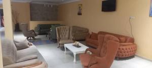 a living room with couches and chairs and a table at Hotel Gabu Karsa in Gabú