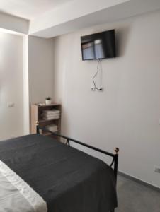 a bedroom with a bed and a tv on the wall at La Casa di Mami in Velletri
