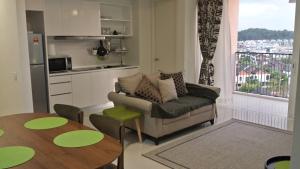 a living room with a couch and a table and a kitchen at Getaway Residence at Cyberjaya in Cyberjaya