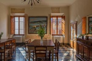 a dining room with a table and chairs and windows at Il Casone di Rigomagno in Rigomagno