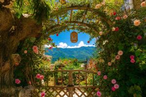 an archway with flowers and a mountain in the background at Sweet August · Boutique Hotel (Dali Erhai) in Dali