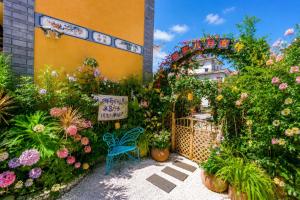 a garden with flowers and plants in front of a building at Sweet August · Boutique Hotel (Dali Erhai) in Dali