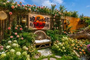 a garden with a bench and flowers on a fence at Sweet August · Boutique Hotel (Dali Erhai) in Dali +69 photos