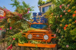 an orange truck is covered in flowers at Sweet August · Boutique Hotel (Dali Erhai) in Dali