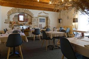 a dining room with tables and chairs and a stone wall at Villla DUO in Besançon