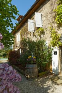 a building with a barrel with flowers in front of it at Villla DUO in Besançon