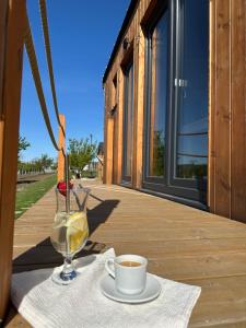a cup of coffee and a glass of wine on a table at Tiny house Pálava in Bořetice