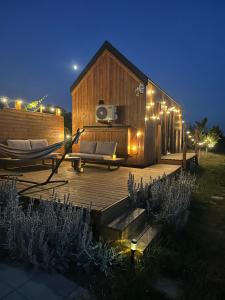 a house with a hammock on a deck at night at Tiny house Pálava in Bořetice +17 photos