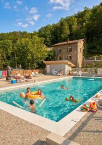 a group of people swimming in a swimming pool at Camping Hôtel Maui in Tournon-sur-Rhône
