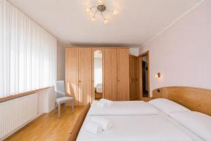 a bedroom with two beds and a chandelier at Appartamenti Cèsa Sorèie by AMA Val di Fassa in Canazei