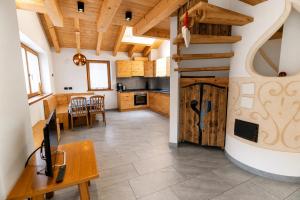 a large kitchen with a table and a wooden door at Appartamenti Cèsa Sorèie by AMA Val di Fassa in Canazei