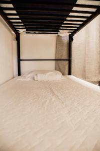a large white bed in a room at Villa Palmarcito in El Zonte