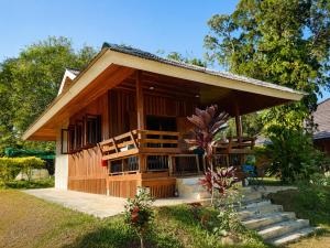 a small house with stairs leading up to it at Aruna Mountain Lodge in Ban Huai Rin
