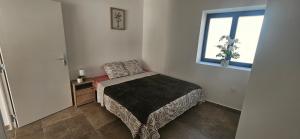 a small bedroom with a bed and a window at L'escalade Lyon Aéroport in Janneyrias