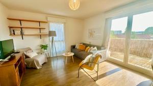 a living room with a couch and a tv at Rotamagus Officiel in Rouen