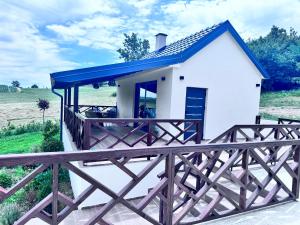 a small white house with a blue roof at SoL Zlatni koreni in Palanka