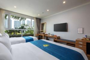 a hotel room with two beds and a flat screen tv at Oriana Hotel in Hanoi +17 photos