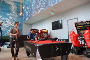 two men standing next to a pool table at MEININGER Hotel Amsterdam Amstel in Amsterdam