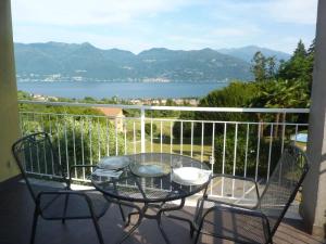 a table and chairs on a balcony with a view of the water at BlueVille21 in Germignaga