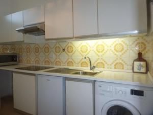 a kitchen with a sink and a washing machine at BlueVille21 in Germignaga