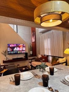 a living room with a table and a television at Sharma Nosso Canto in Arayat