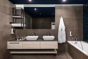 a bathroom with two sinks and a tub and a mirror at LUA Boutique RoomZ- Adults only in Balatonfüred +14 photos