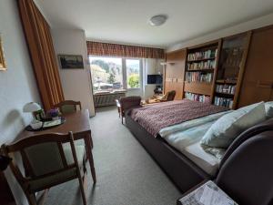 a bedroom with a bed and a table and a window at Haus Kiel Wohnung Wolfswarte in Altenau