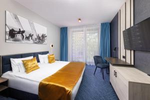 a hotel room with a bed and a flat screen tv at LUA Boutique RoomZ- Adults only in Balatonfüred