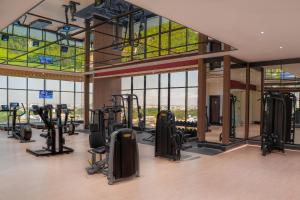 a gym with treadmills and elliptical machines at The Trans Luxury Hotel Surabaya in Surabaya